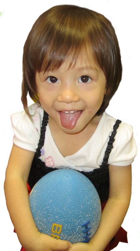 young girl with tongue out and carrying a football